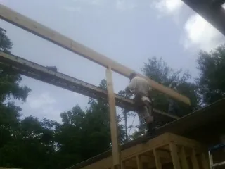 Carpenter setting a ridge beam over a new addition frame — Ice Dam Removal by Roofing Brothers in Bell Gardens