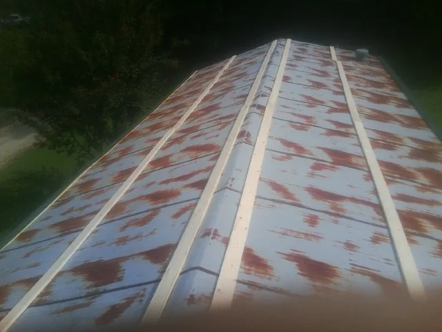 Rusted metal roof panels with new wood purlins before replacement — Storm Damage Roof Repair in Bell Gardens by Roofing Brothers