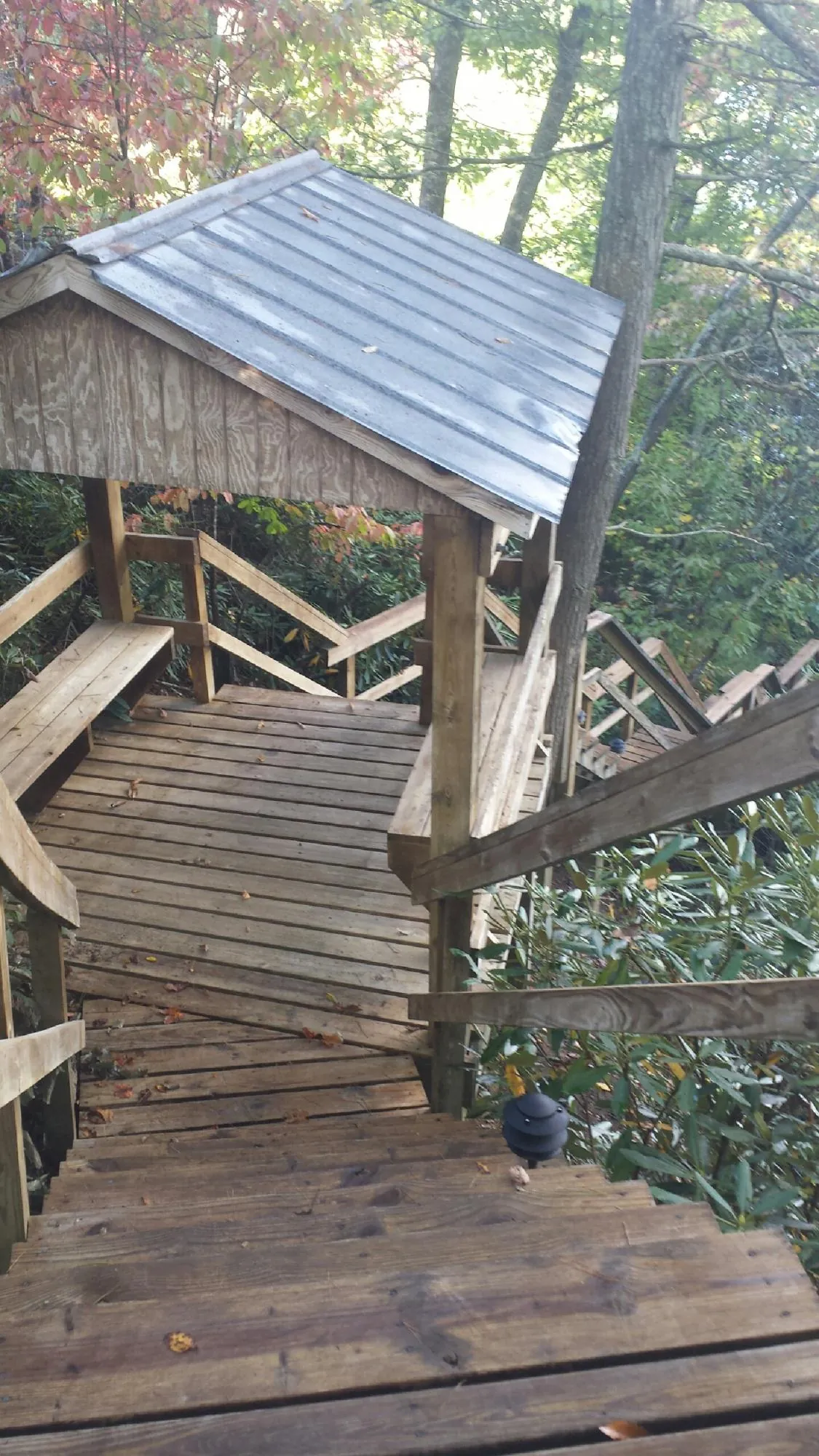 Metal roofed shelter over wooden steps on a wooded walkway — Skylight Repair & Installation work by our crew in Bell Gardens