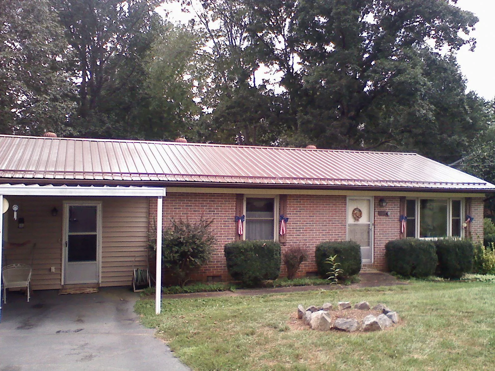 Bronze metal roof and carport on a brick ranch home — Roof Repair work by our crew in Bell Gardens